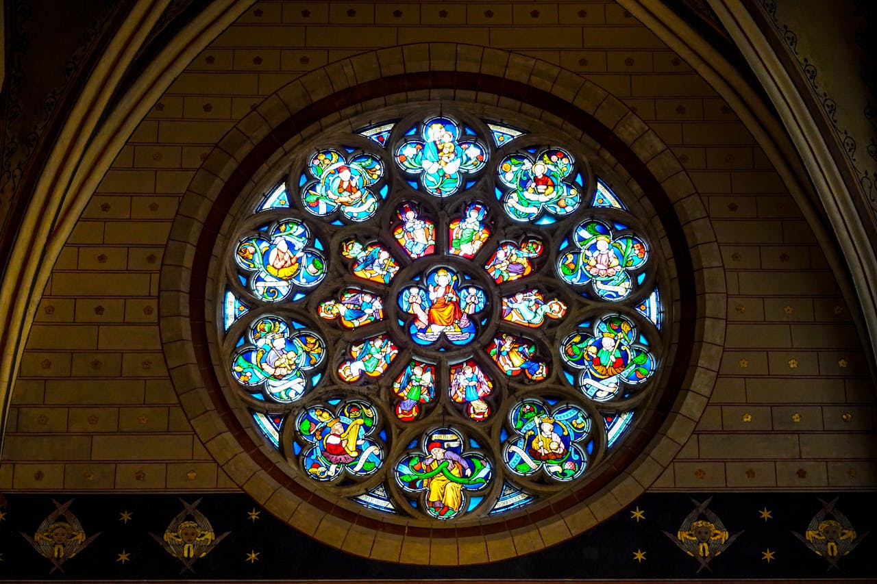 Intricate Gothic stained-glass window showcasing vibrant religious art in a cathedral.